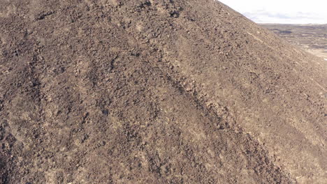 aerial fly around view of the abstract texture of the ground around the volcanic amboy crater in the mojave desert