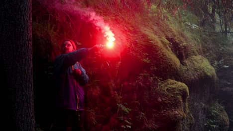 person with red flare in forest