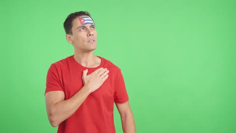 man listening to the cuba national anthem with solemnity