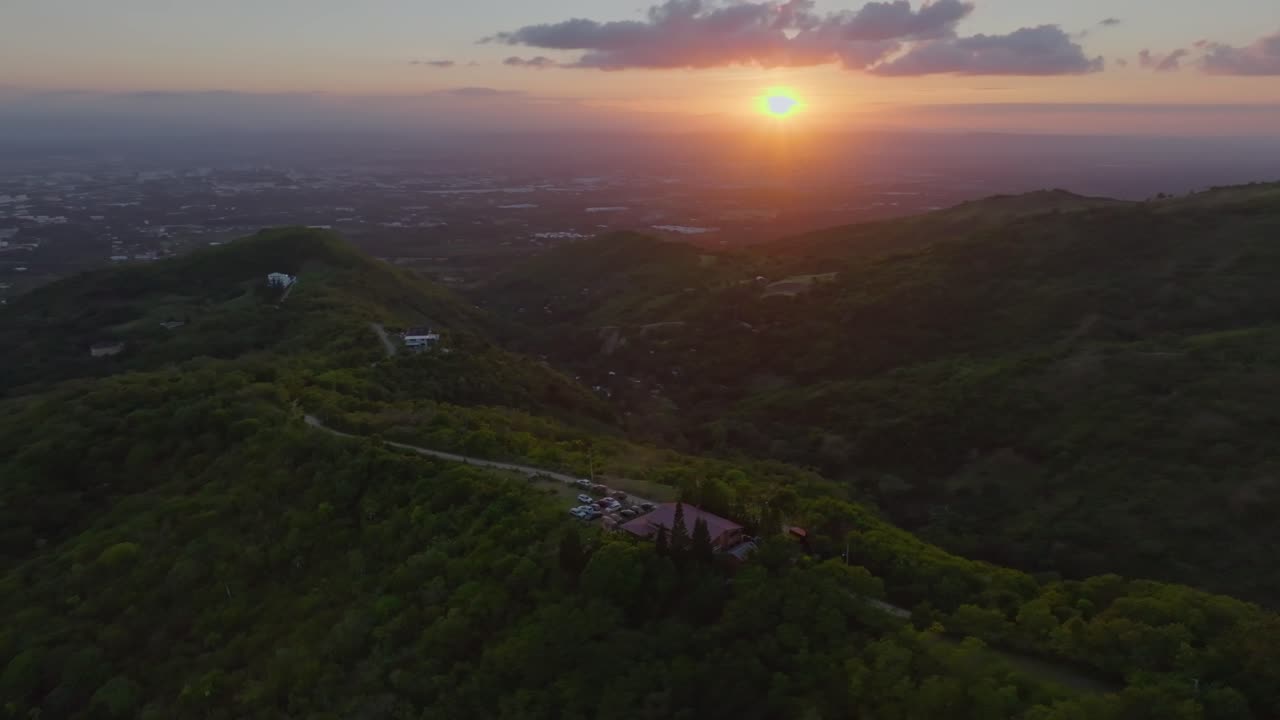 arco aéreo escénico de la puesta del sol sobre el edificio en las montañas de santiago, república dominicana