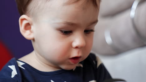 face of the cute caucasian baby with dark hair. beautiful child looking around with interest. close up.