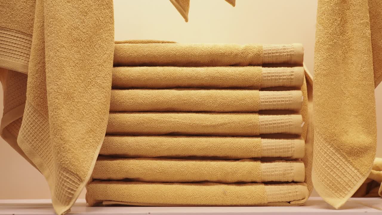 베이지색 수건 한 어리가 접혀서 사용할 준비가 되어 있습니다.