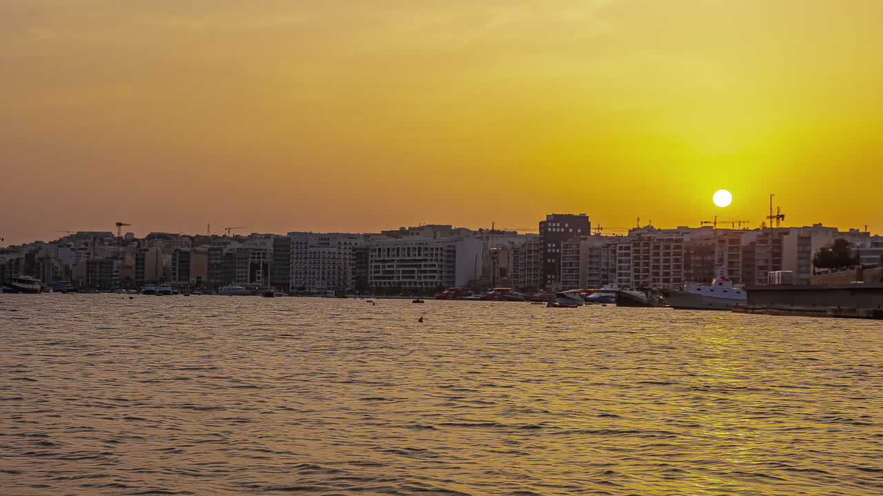gzira, malta y el puerto durante una puesta de sol dorada - lapso de tiempo