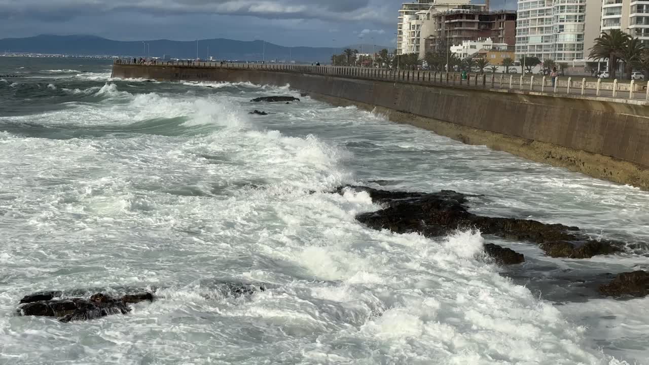 Le onde si infrangono sugli scogli vicino al faro di Città del Capo a Mouille Point