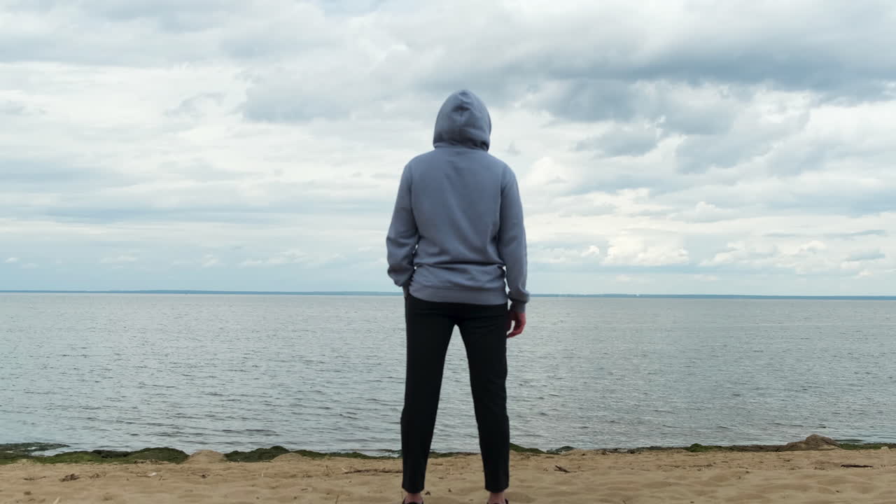 Person Standing on Beach Looking at the Ocean