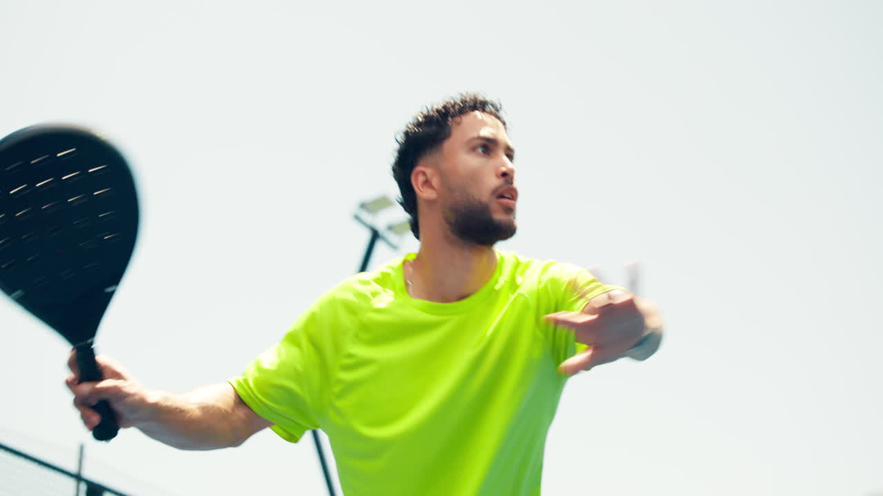 Uomo che gioca a padel tennis su un campo all'aperto in una giornata di sole
