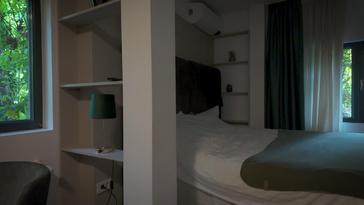 Hotel room with bed and table lamp by window