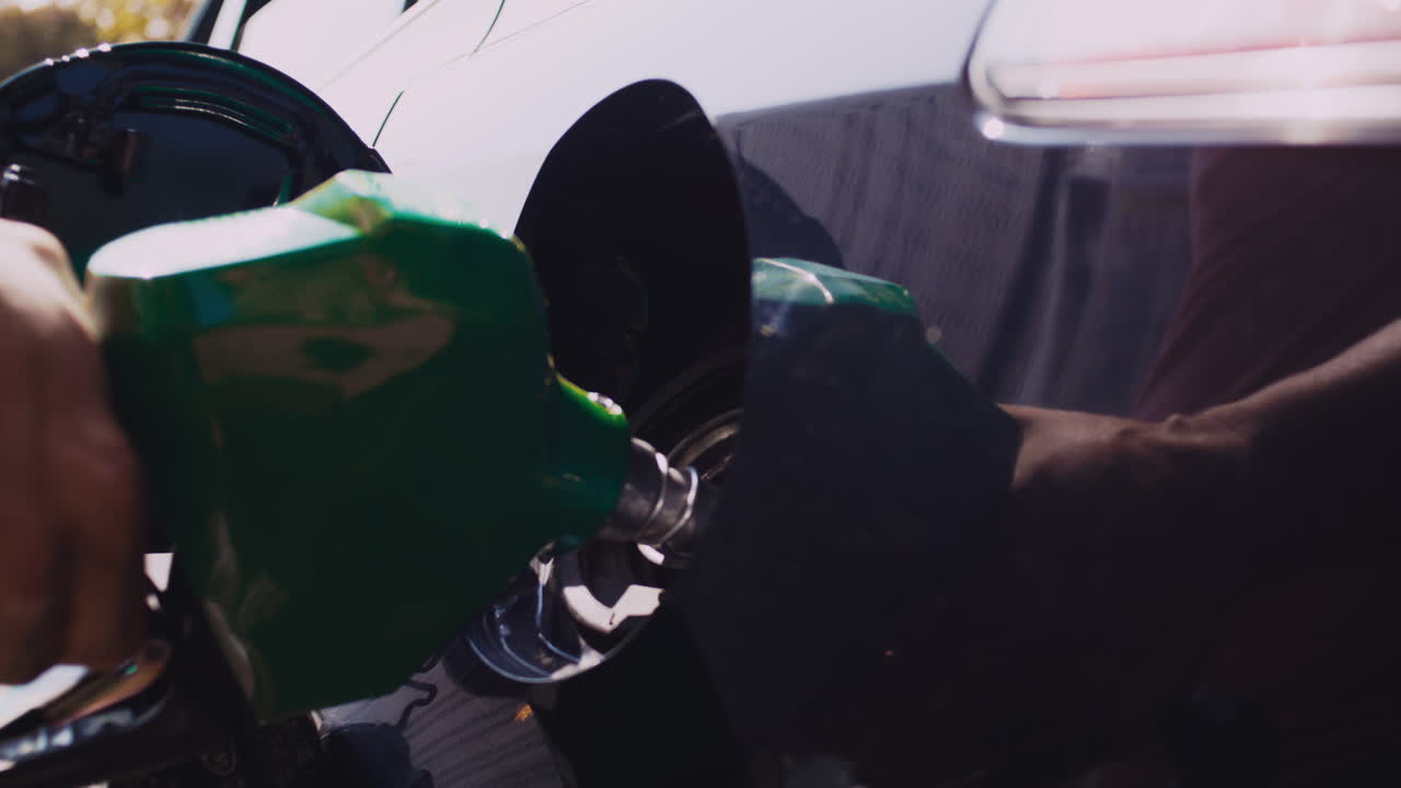 라틴계 남자가  ⁇ 은 날 주유소에서 토요타 프리우스에 가스  ⁇ 프를  ⁇ 입하는 백라이트 클로즈업