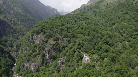 desfiladero de montaña debajo bosque verde pie de montaña iglesia italia aérea