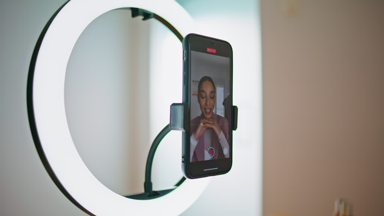 en primer plano, una persona de los medios de comunicación grabando un tutorial en la pantalla de un teléfono inteligente. una mujer hablando.