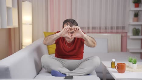 man making heart symbol for camera.