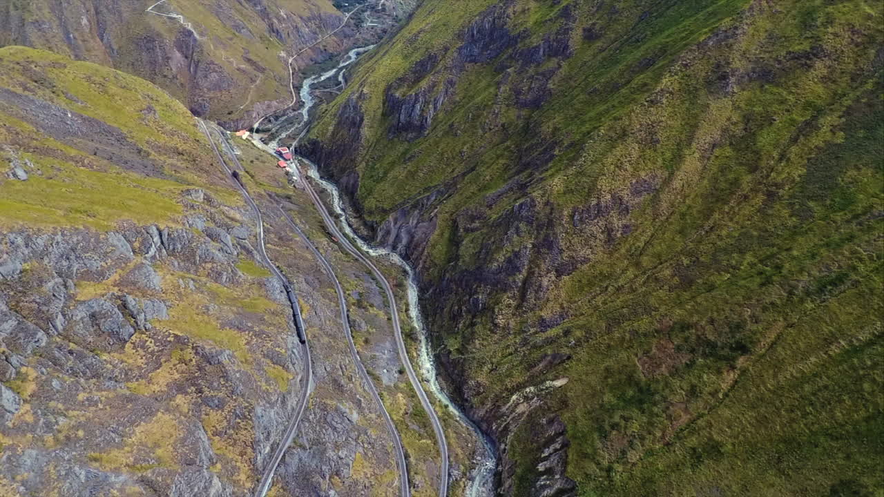 una toma aérea de un tren dando la vuelta a la "nariz del diablo" o la nariz del diablo en alausí, provincia de chimborazo, ecuador