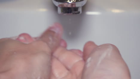 extreme close up slow motion man washing male hand with a lot of soap