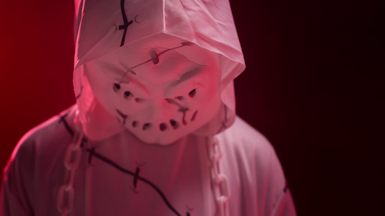 niño vestido de fantasma zombie monstruo disfraz truco o trato en halloween asustando a la gente contra el fondo de humo rojo 6