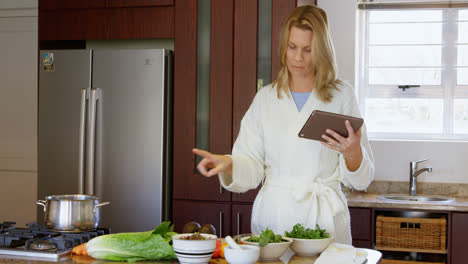 Woman-checking-recipe-on-digital-tablet-in-kitchen-4k