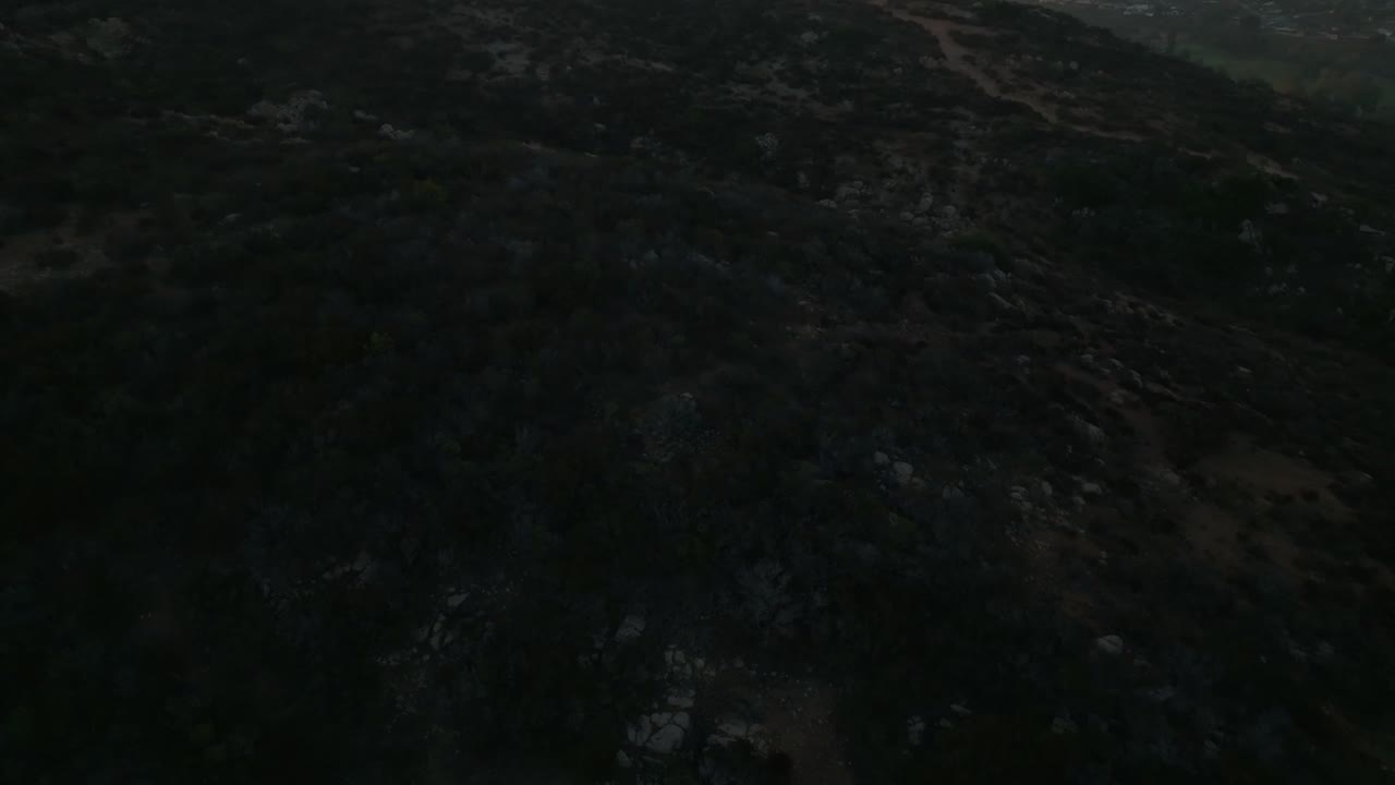 vista aérea de la ruta de senderismo en la montaña cowles durante el amanecer que se inclina hacia arriba, revelando la ciudad vecina de san carlos y las curvas en san diego, california, ee.uu.