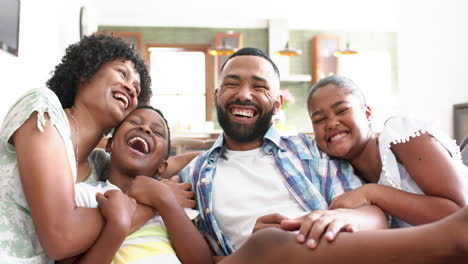 Portrait-of-happy-african-american-parents,-daughter-and-son-embracing-in-living-room,-slow-motion