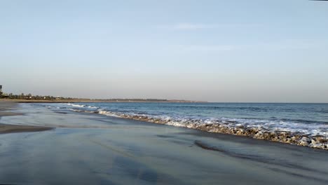 slow motion of small waves of the sea arrive creating white foam on sand, on a clear day, waves coming to the beach shore, full hd