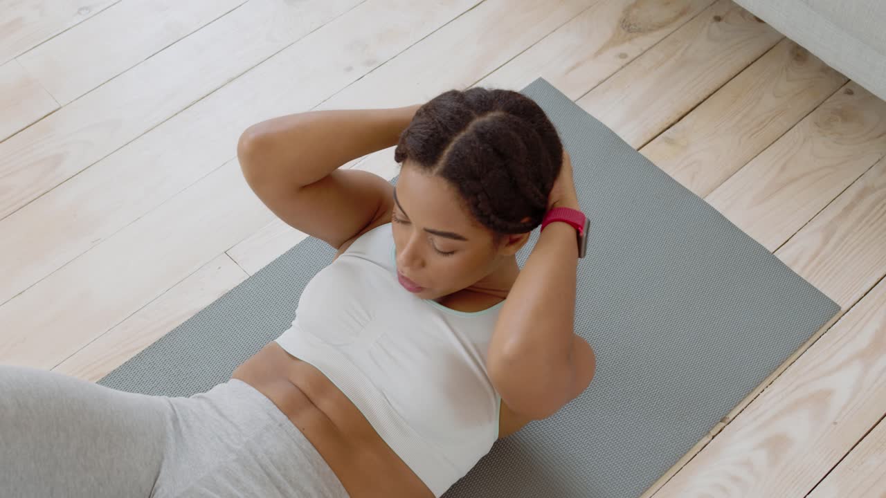 mujer haciendo abdominales en una alfombra de yoga
