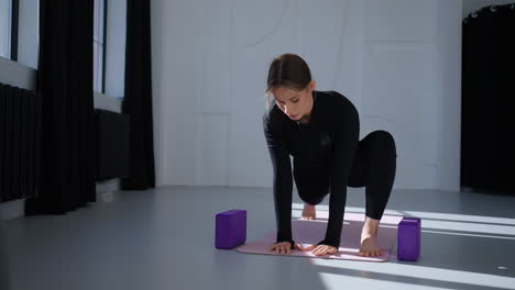 woman doing yoga stretching exercise in a studio