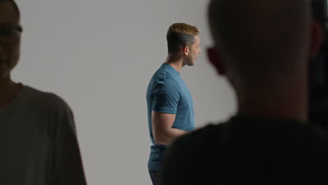 film director talking with male and female actors holding scripts rehearsing for shooting movie or video in studio 4