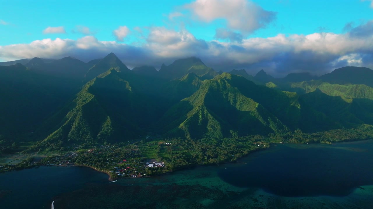 Tahiti lagoon jet skis landscape aerial drone harbor view French Polynesia Teahupo'o surf wave Passe Havea coral reef South Pacific Ocean island golden sunny volcano peaks low clouds coastline circle