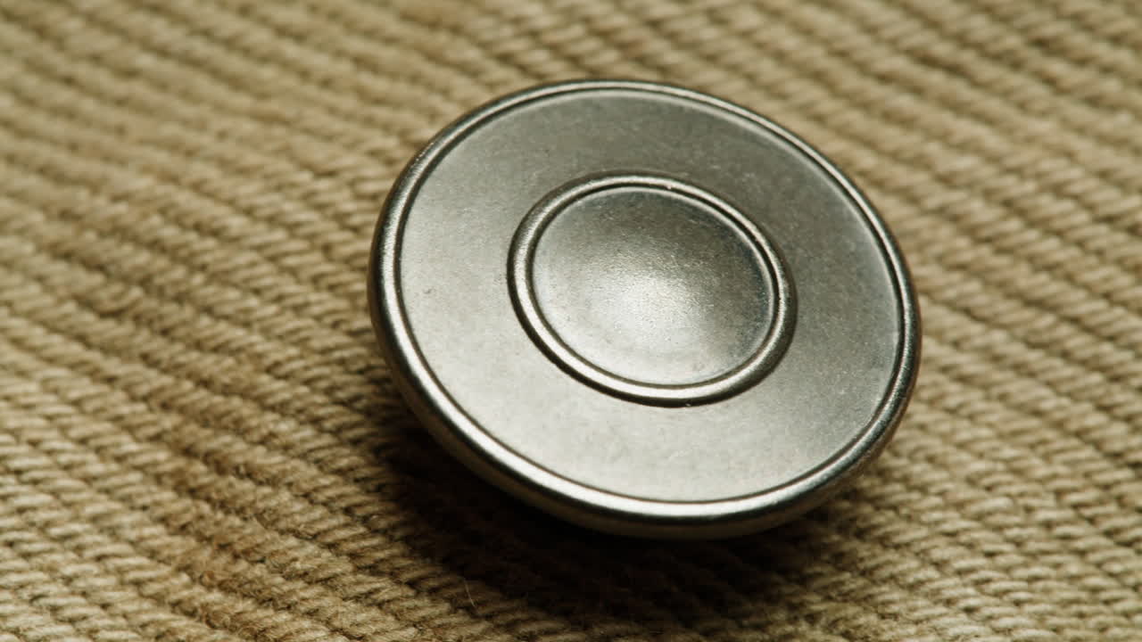 Close-up of a metal button on corduroy fabric