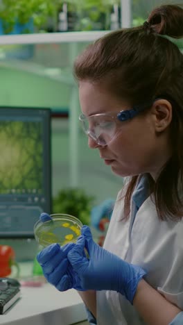 female scientist examining a sample in a petri dish in a laboratory