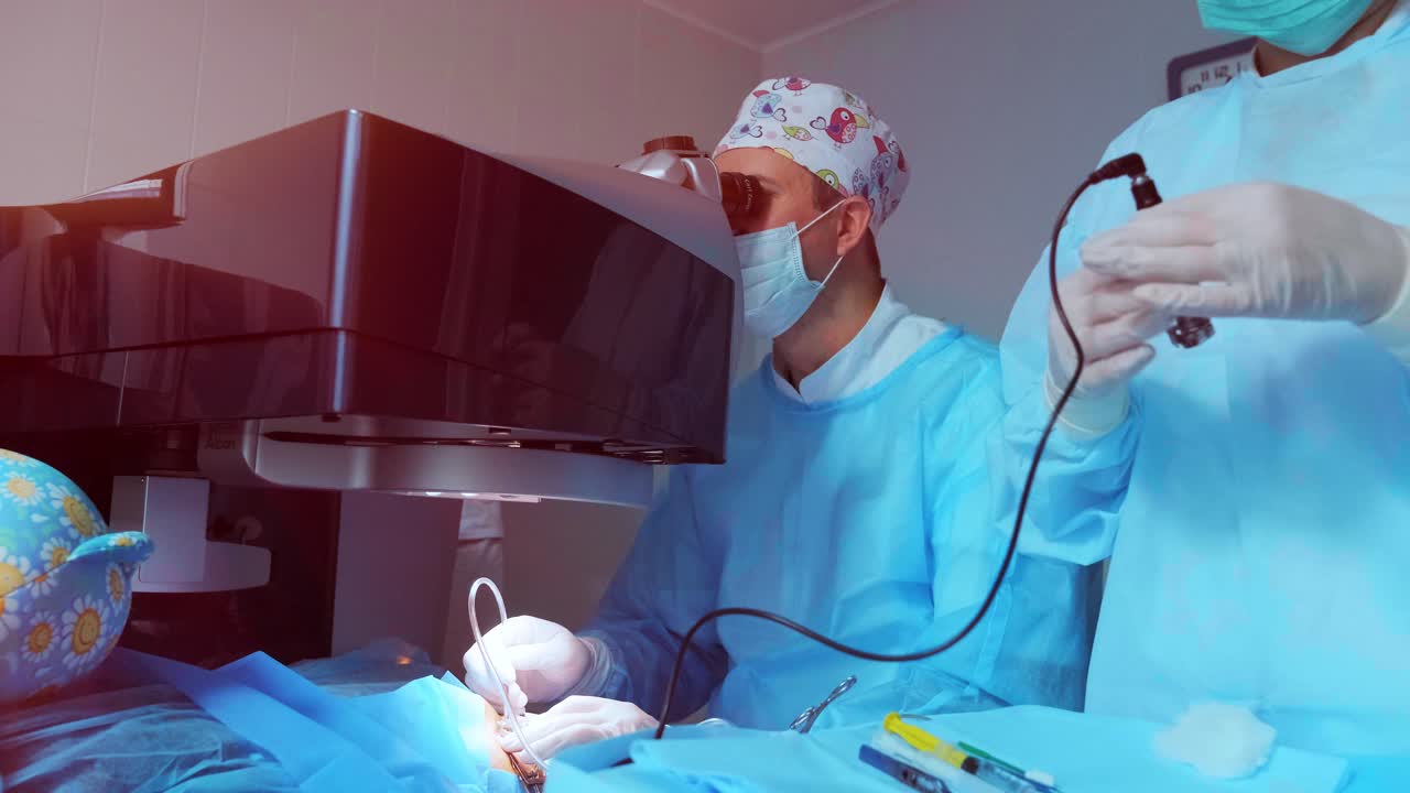 cirugía ocular. un paciente y un cirujano en la sala de operaciones durante una cirugía oftalmológica. paciente bajo microscopio quirúrgico. corrección de la visión