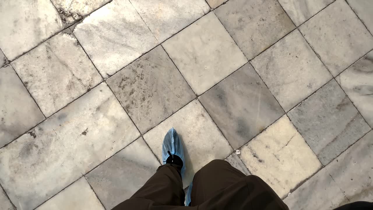 A Person Feet Covered Walking On Tiled Floors Of Taj Mahal Mausoleum In Agra, India. POV Shot