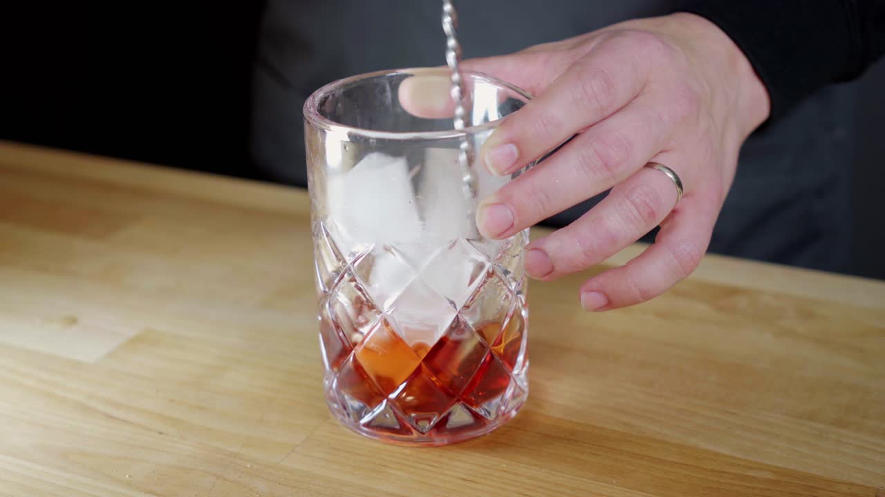 revolviendo un negroni en un vaso mezclador