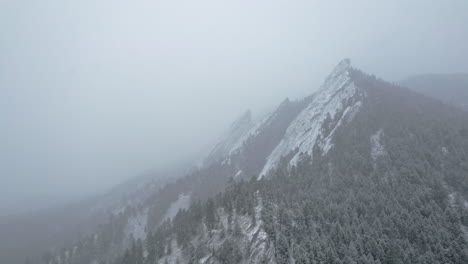 Imágenes-Aéreas-De-Drones-Volando-Hacia-La-Montaña-Flatirons-Cubierta-De-Nieve-Cerca-De-Boulder-Colorado-Usa-Durante-La-Ventisca-De-Tormenta-De-Nieve