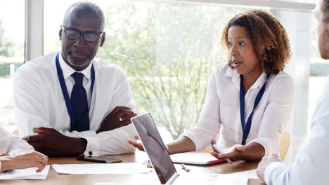 Business-Team-Having-Meeting-Around-Table-In-Modern-Office