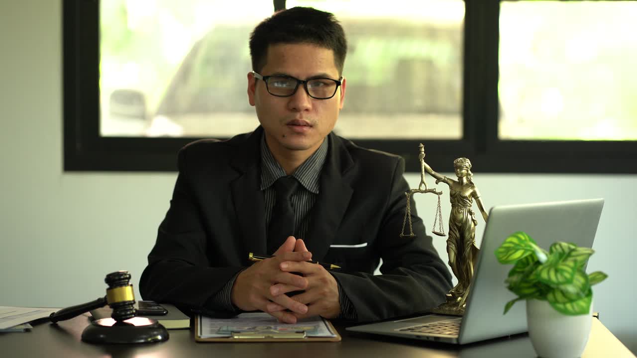 concepto de justicia y ley un abogado masculino trabaja en una oficina con una diosa de bronce en una mesa de madera martillo de justicia con computadora portátil conceptos legales y servicios legales