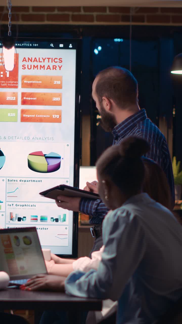 Vertical video: Company analyst explaining statistics graphs visualization in business meeting