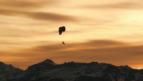paragliding at sunset over mountains