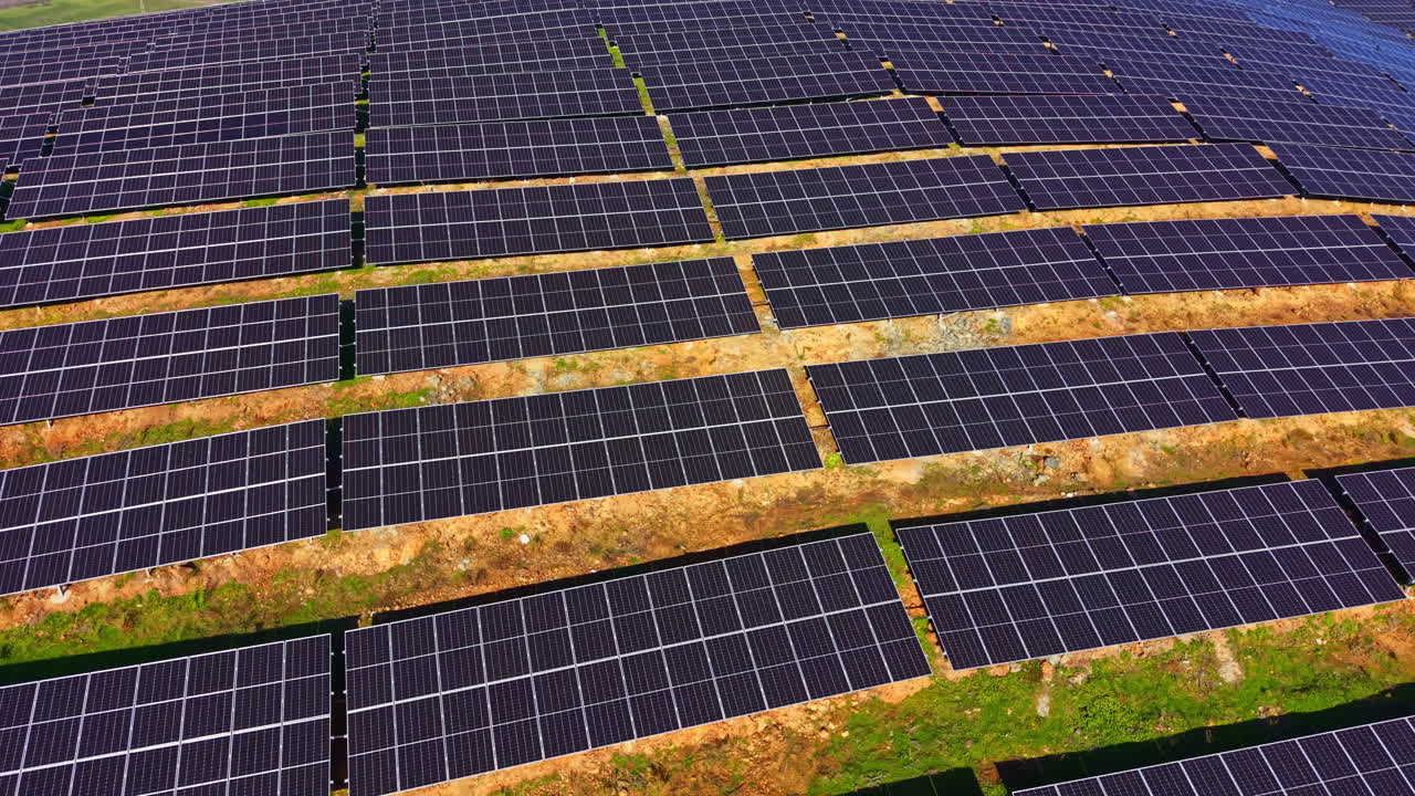 Pannelli solari innovativi si estendono su un vasto paesaggio, sfruttando la luce solare per fornire energia rinnovabile alla comunità durante un luminoso pomeriggio