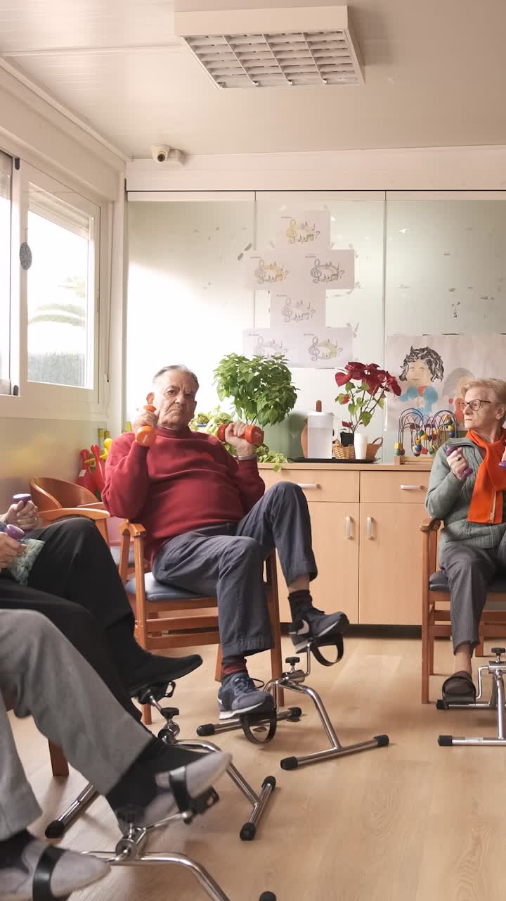 Senior men and women doing pedal exercises and lifting dumbbells at rehabilitation center