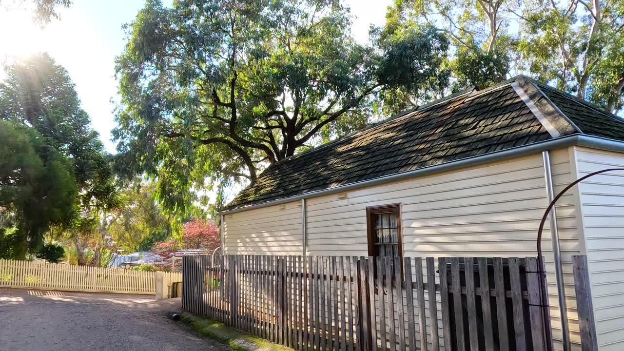 A serene view of a historic cottage surrounded by trees in Ballarat, Australia, captured with gentle camera movement and natural lighting