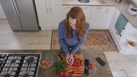 Top-view-of-woman-chopping-vegetables-and-putting-it-in-bowl-in-the-kitchen