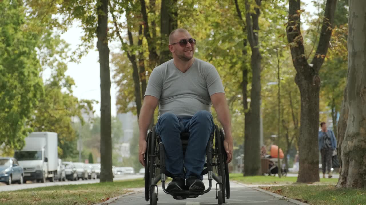Man with disabilities in wheelchair walk at the park alley