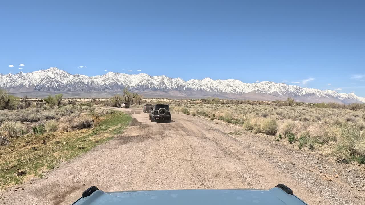 Convoy of overland enthusiasts driving along a dirt trail in California's Alabama Hills - driver point of view