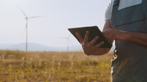 farmer using tablet at wind farm