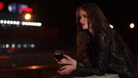 woman drinking wine at night in the city