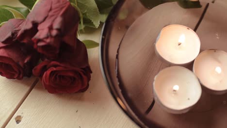 Floating-tea-lights-and-bouquet-of-red-roses-background