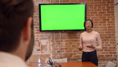 mujer de negocios de pie junto a la pantalla para dar una presentación