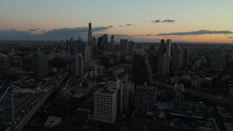 Aerial-panoramic-footage-of-Downtown-Brooklyn-at-dusk.-Busy-roads-leading-from-bridges-and-high-rise-office-of-apartment-buildings-in-city.-Brooklyn,-New-York-City,-USA