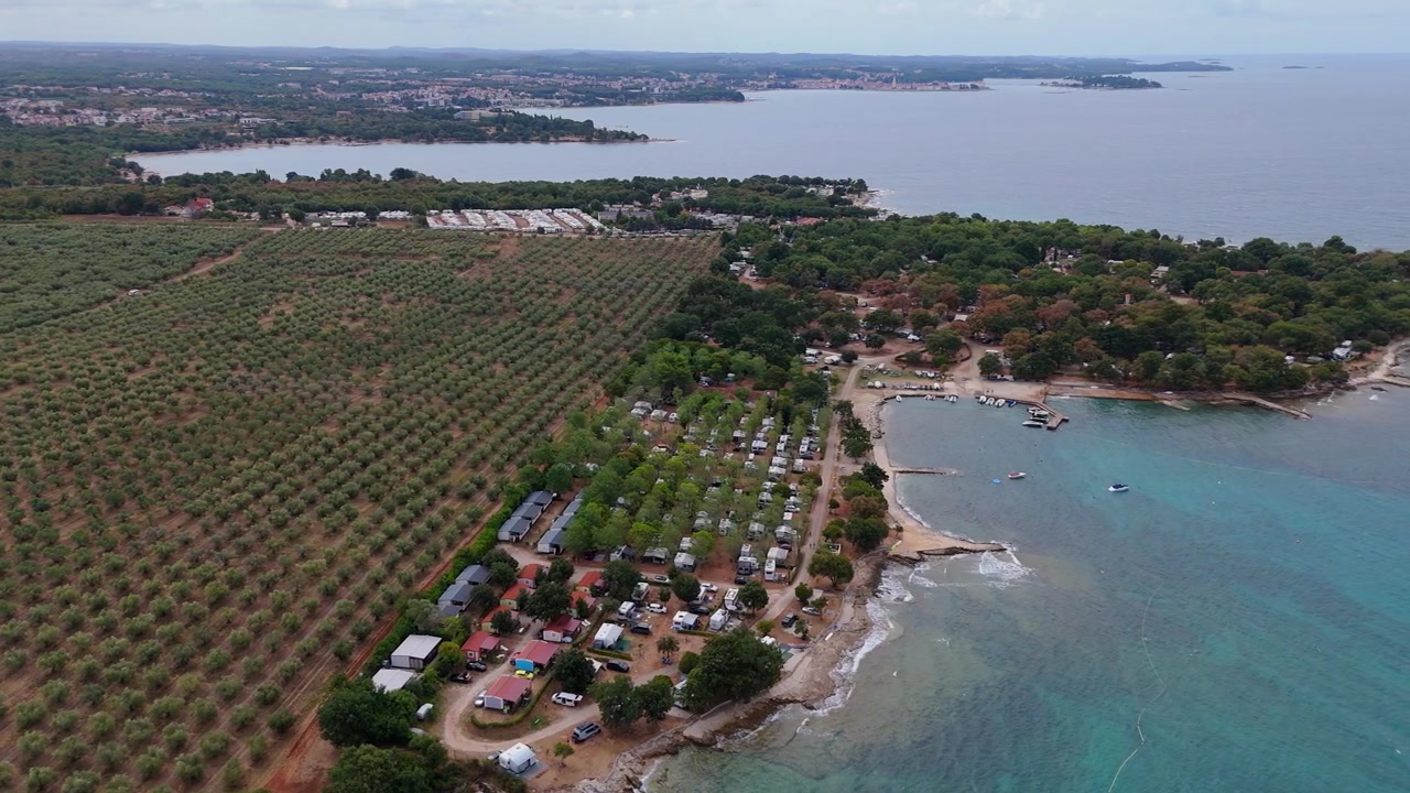 FKK Camping Ulika vicino a Parenzo con camper, vista aerea con drone durante una soleggiata giornata estiva sulla splendida costa adriatica in Istria, Croazia.