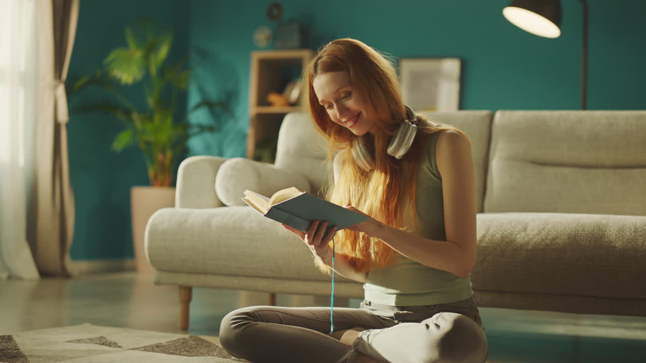 Woman reading book sitting on floor