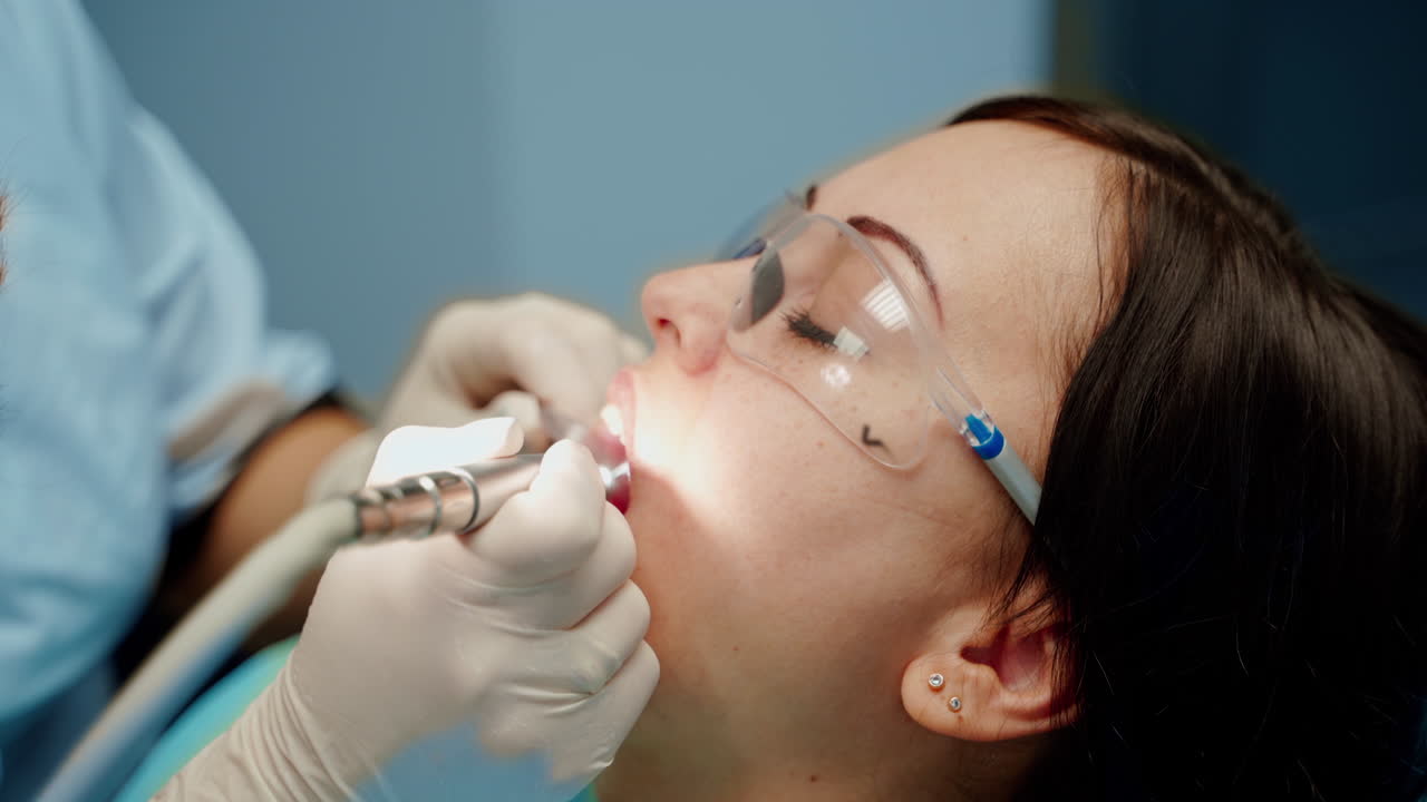 Il medico cura i denti del paziente. Giovane donna attraente in clinica stomatologica con il dentista